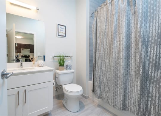 a bathroom with a shower and a toilet next to a sink