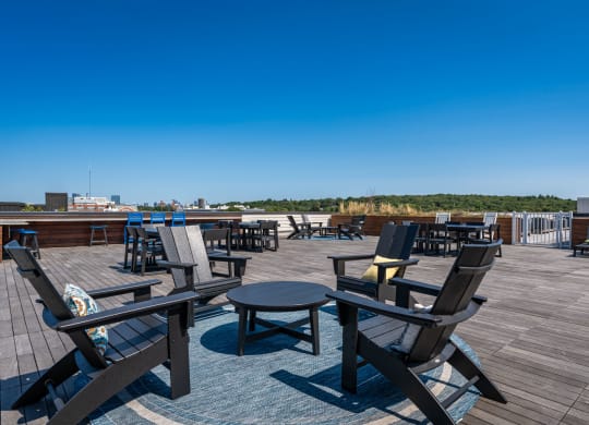 a roof deck with tables and chairs on top of a building