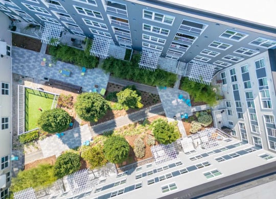 an aerial view of an apartment building with a green courtyard