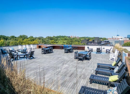 the deck on the top of the building has tables and chairs