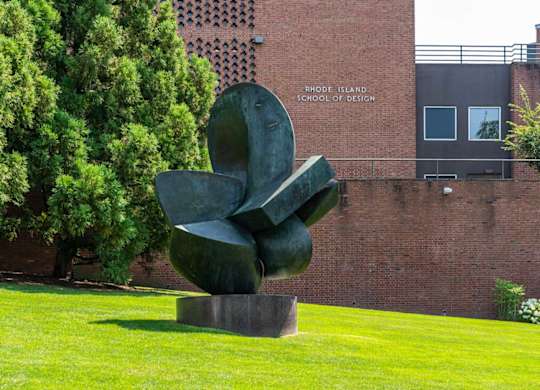 A large sculpture sits on a pedestal in front of the Rhode Island School of Design.