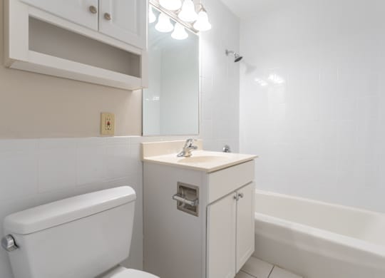 bathroom with bright vanity and white tiling