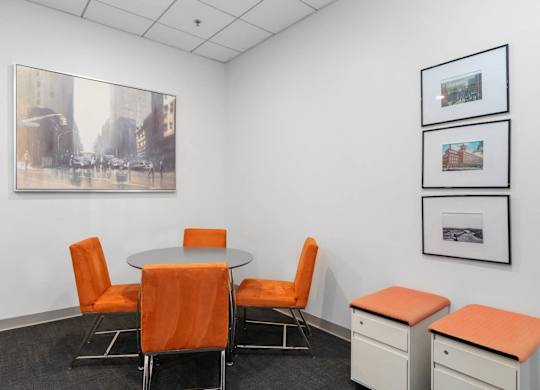 A conference room with a table, chairs and pictures on the wall.
