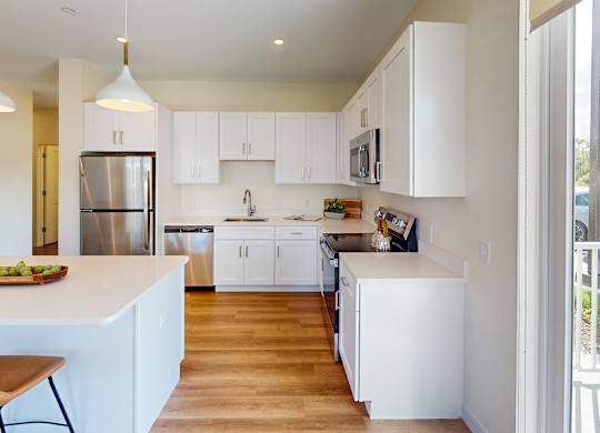 A kitchen with white cabinets and a wooden island.