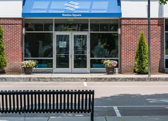 a bench in front of a building with a blue awning