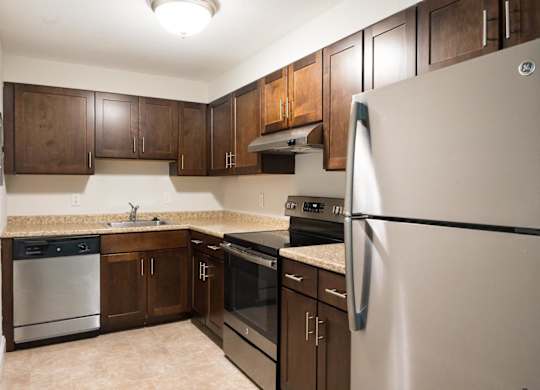 a kitchen with dark wood cabinets and stainless steel appliances