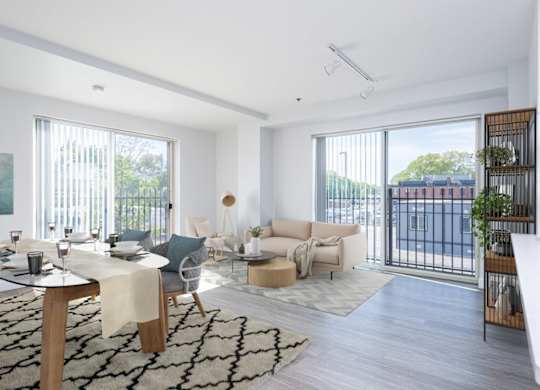 View of the living room and and dining room at Munroe Place in Quincy- virtually staged