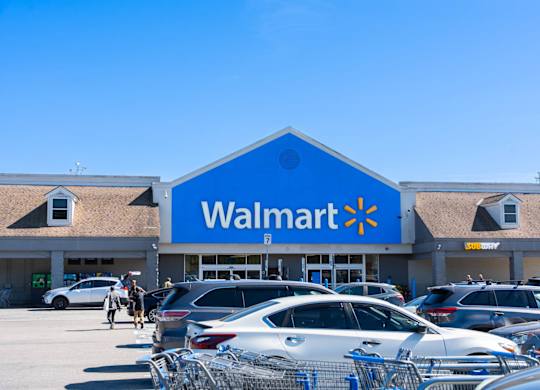 A Walmart store with cars parked in front.