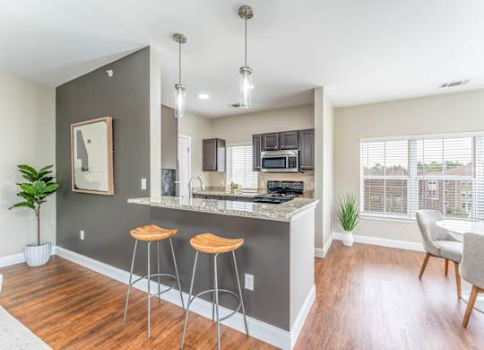 A kitchen with a bar area and a dining table.