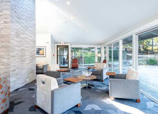 Tablet chairs at Weymouth Commons with a view of the pool