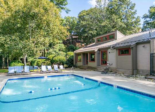 a swimming pool in front of a house with a pool