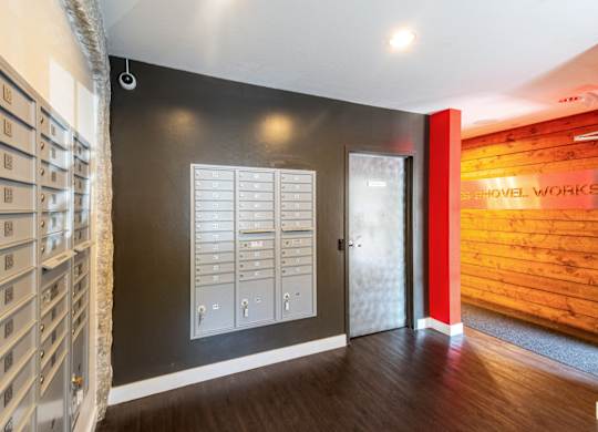 a hallway with a door to a wine room and a wall with a wooden wallat Ames Shovel Works Apartments, North Easton, MA, 02356