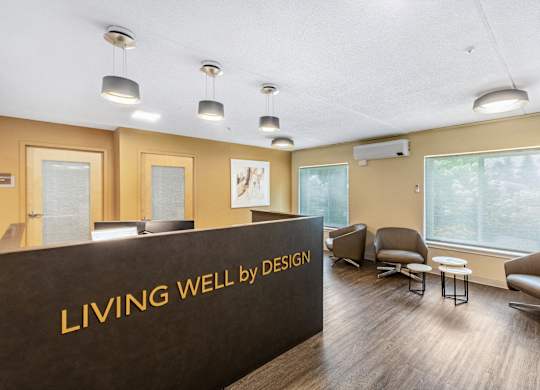 a living well by design lobby with chairs and a reception desk at North Stoughton Village, Massachusetts