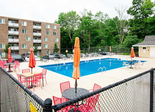 our apartments have a large pool and a patio with chairs at North Stoughton Village, Massachusetts