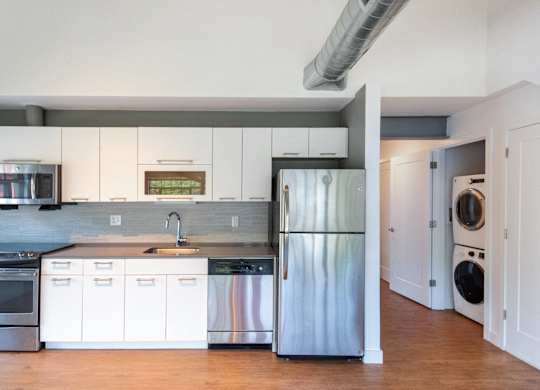 a kitchen with white cabinets and stainless steel refrigeratorat Ames Shovel Works Apartments, Massachusetts, 02356