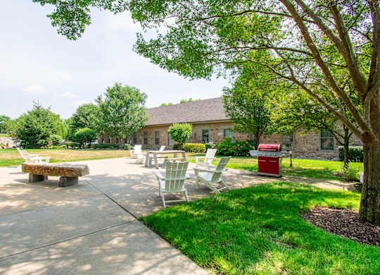 a patio with chairs and a picnic table in front of a buildingat Ames Shovel Works Apartments, North Easton, MA