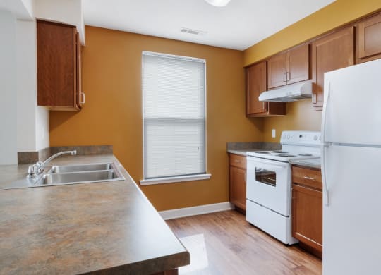 a kitchen with white appliances and wooden cabinets at Waterfront Apartments, Buffalo, NY