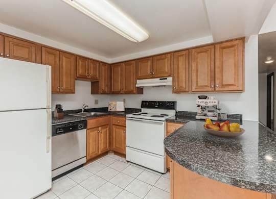 a kitchen with white appliances and granite counter tops at Bates Hill Apartments Pittsburgh, PA.