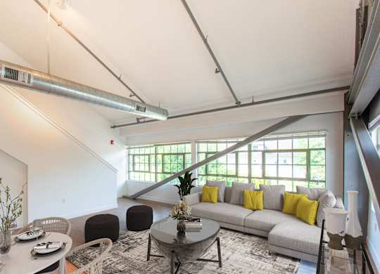 a living room with a gray couch and a coffee tableat Ames Shovel Works Apartments, North Easton, MA, Massachusetts