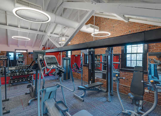 a gym with weights and cardio equipment and a brick wall at Ninth Square Apartments, Connecticut, 06510