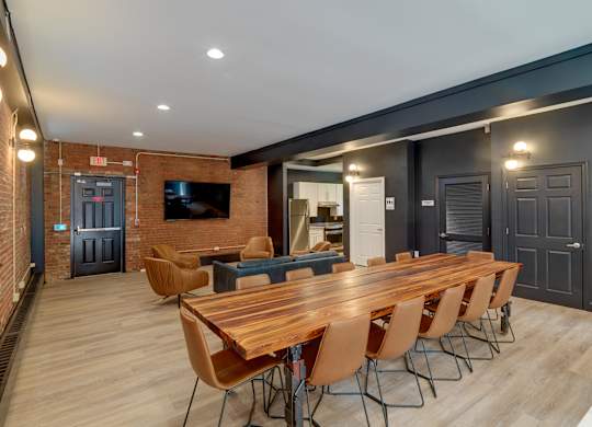 Community room with a long wooden table and chairs and tv at Ninth Square Apartments, Connecticut
