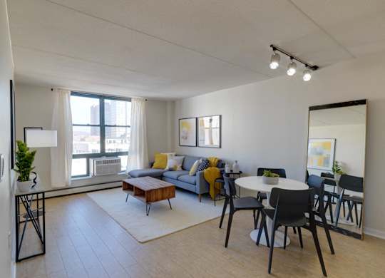 an open living room and dining room with a table and chairs and a large window at Ninth Square Apartments, Connecticut
