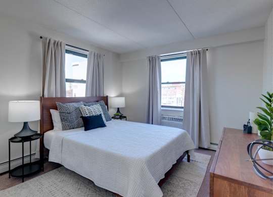 a bedroom with a large bed and two windows at Ninth Square Apartments, Connecticut, 06510