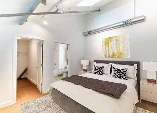 a bedroom with a large bed and a closetat Ames Shovel Works Apartments, North Easton, Massachusetts
