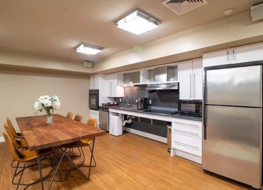 Community Room Area With Kitchen And Tables Wilber School Apartments.
