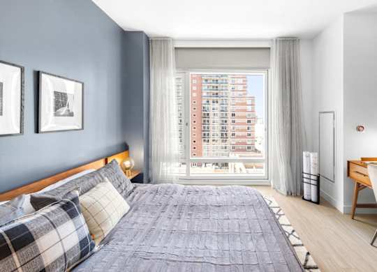 a bedroom with a bed and a large window
