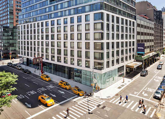 A street view of a city with a large building in the middle.