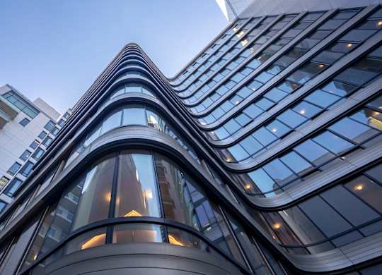 A modern building with curved glass windows and a reflective surface.