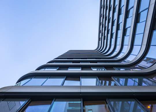 A tall building with a curved design and many windows.
