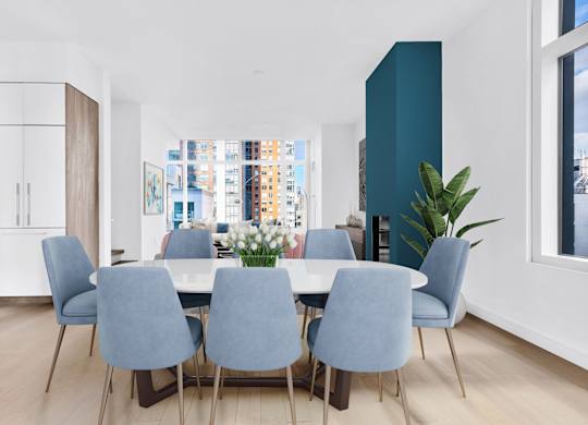 A dining room with a table and chairs.
