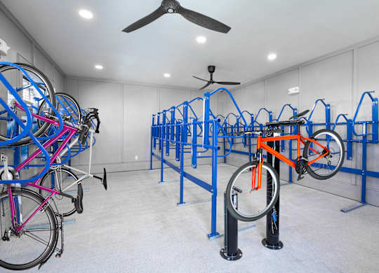 A room full of bicycles with blue racks at 55 Fifty at Northwest Crossing, Houston, TX 77092