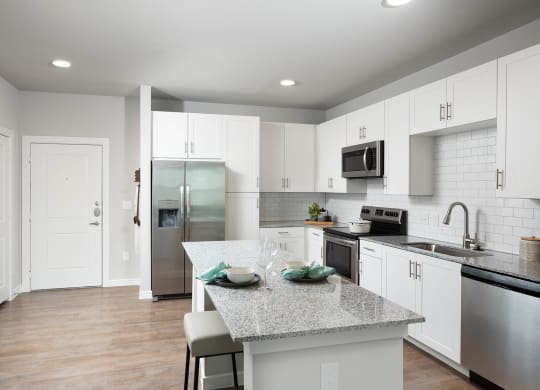 a kitchen with white cabinets and a granite counter top at 55 Fifty at Northwest Crossing, Houston