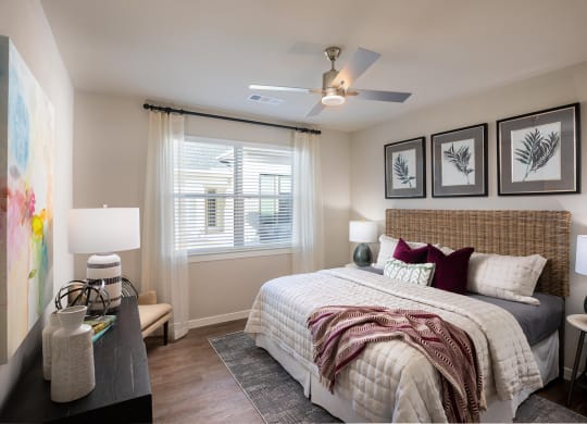 a bedroom with a large bed and a ceiling fan at 55 Fifty at Northwest Crossing, Houston, 77092