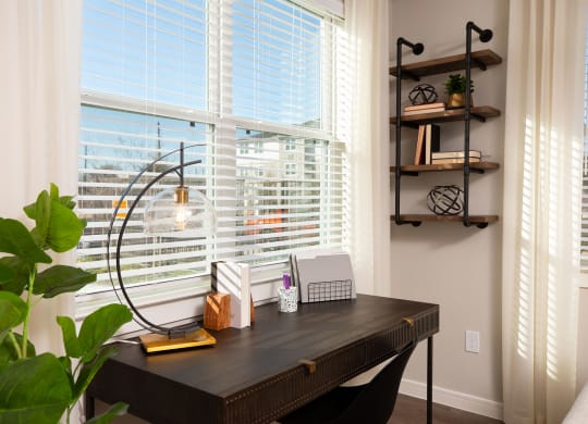 a home office with a large window and a wooden desk at 55 Fifty at Northwest Crossing, Houston Texas