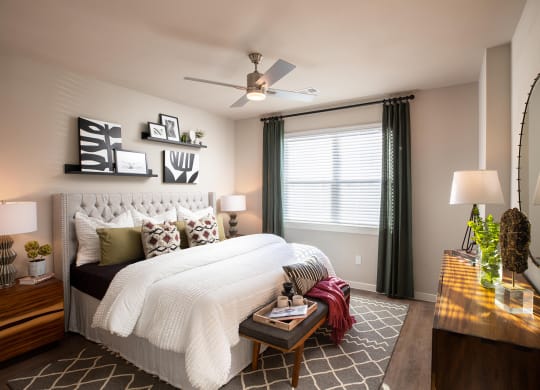 a bedroom with a large white bed and green curtains at 55 Fifty at Northwest Crossing, Houston, 77092