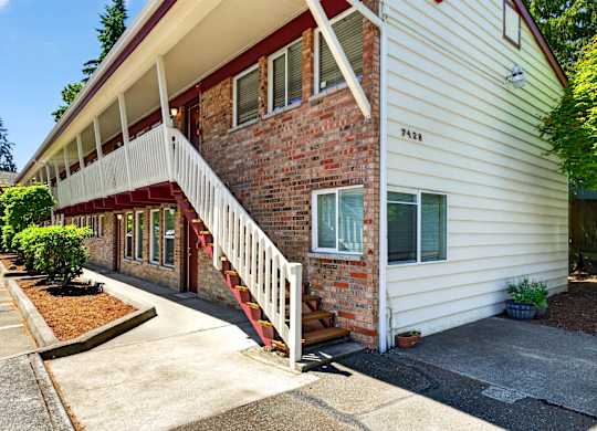 Exterior view of Horizon Park Apartments with white and brick siding and staircase.