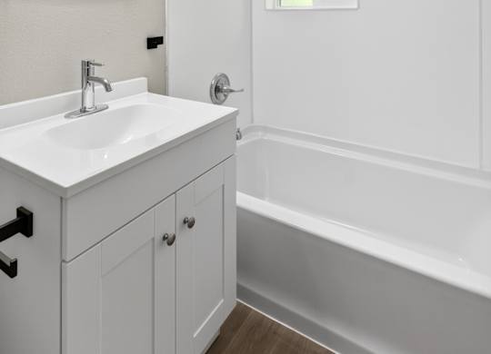 Newly remodeled modern style bathroom with a sink, mirror, and bathtub at Horizon Park Apartments