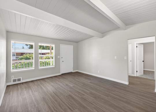 A living room room with a white ceiling and wooden flooring at Horizon Park Apartments