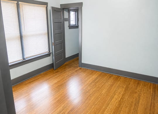 A bedroom with a wooden floor and a grey closeet door at 4729 Roosevelt in Seattle