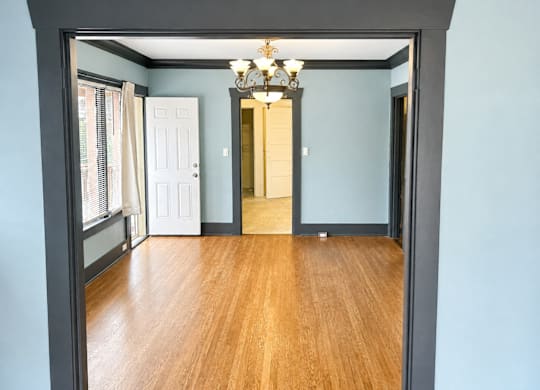 4729Roosevelt DiningRm with a wooden floor and a chandelier.