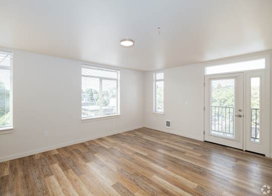 Living Room in Bode125's 1-bedroom apartment with several windows, luxury vinyl plank floors, and white walls
