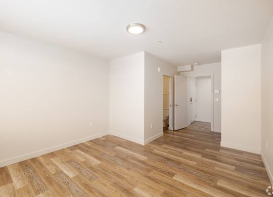 A room with wooden flooring and white walls.