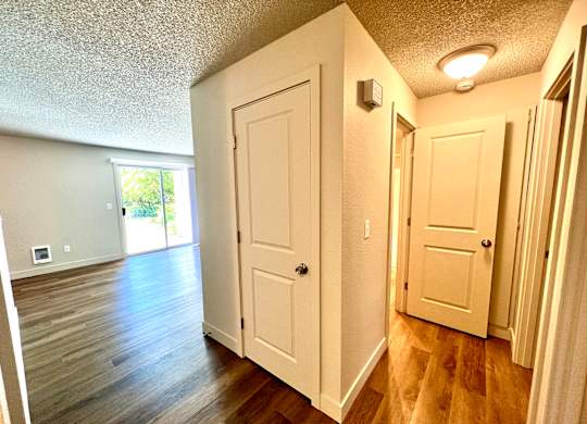 Hallway of 2-bedroom apartment with two storage closets and a sliding glass window.