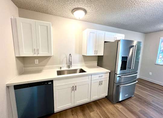 2-bedroom kitchen at Bridgeport Terrace Apartments with white cabinets, white quartz countertops, and stainless steel appliances