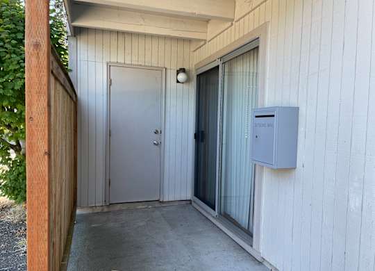 Studio apartment patio with privacy fence and storage door