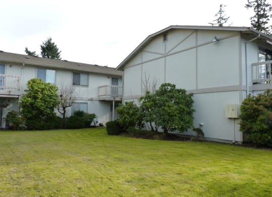 Bridgeport Terrace Apartment white and tan painted building surrounded by trees